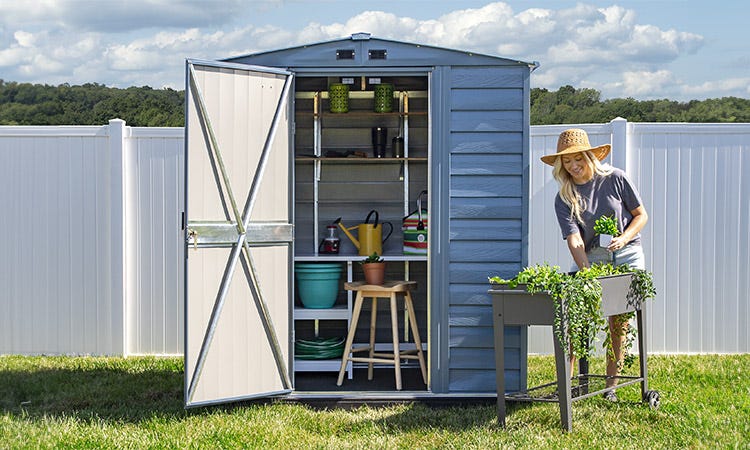 Blue Shed with a woman gardening