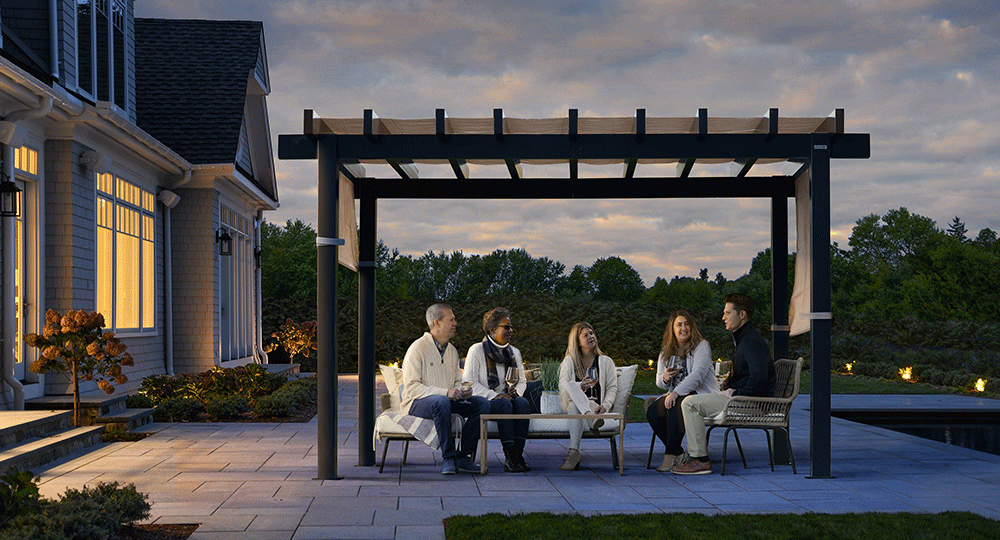 A group of people sitting on a patio underneath a pergola