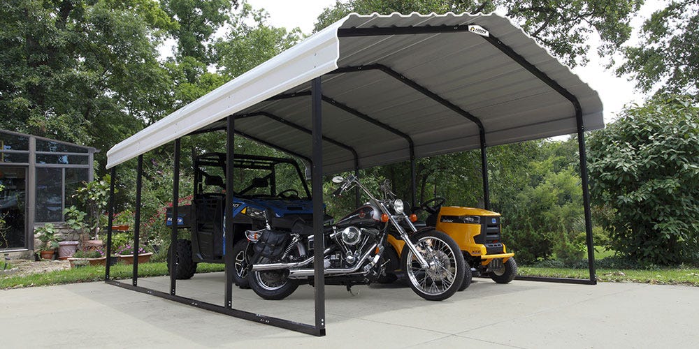 An arrow carport covering an ATV, a motorcucle, and a riding mower.