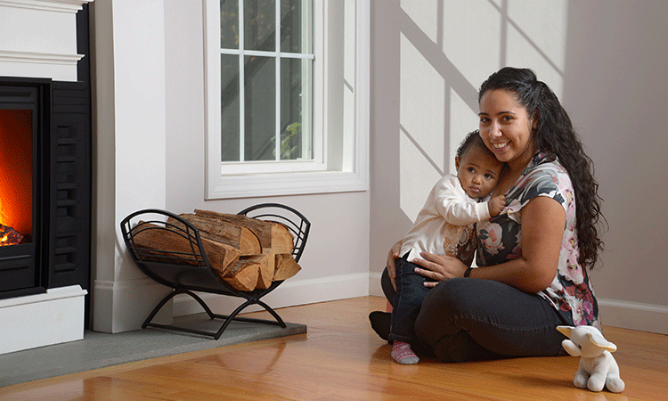 A woman and her baby in front of the fireplace